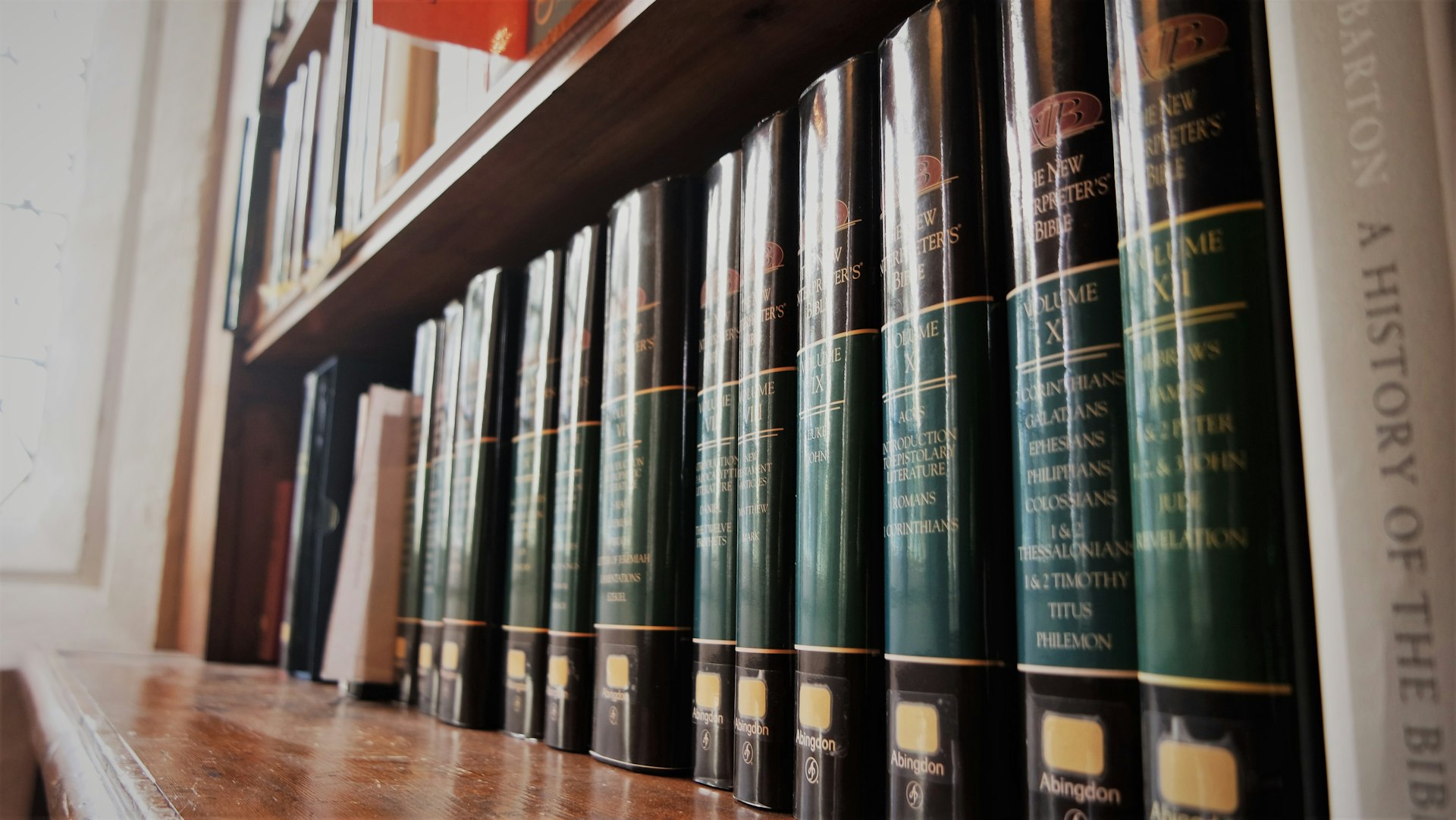 a row of books sitting on top of a wooden shelf
